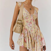Woman wearing a floral dress with a beige bag