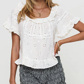 White ruffled blouse worn by a person - front view