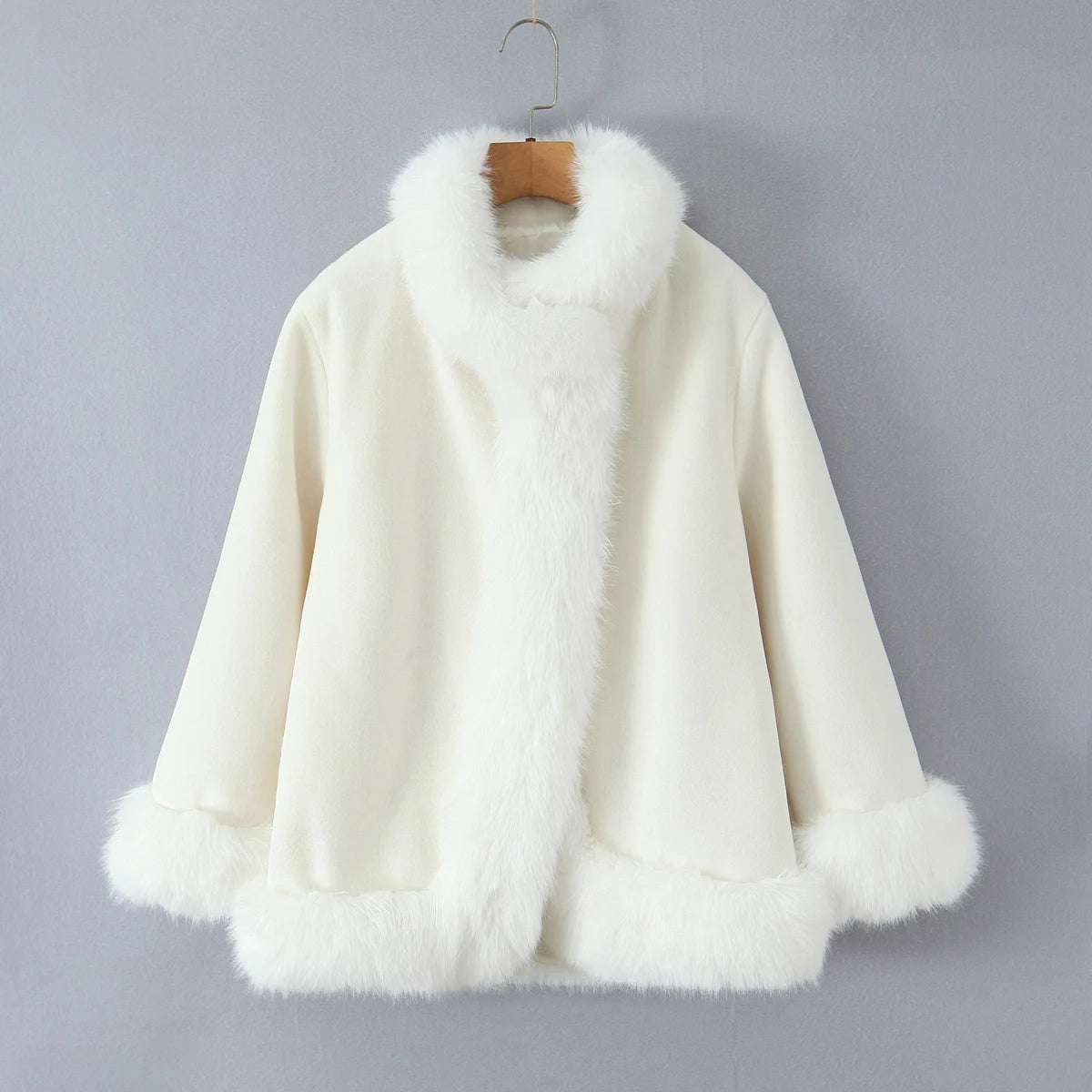 White fur coat on a hanger against a gray background