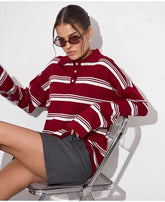 Woman wearing a red and white striped sweater sitting on a chair against a white background