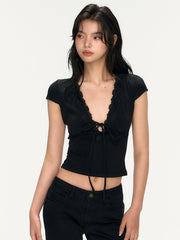 Woman wearing a black crop top with a bow detail