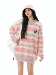 Person wearing a pink and white striped sweater with a butterfly design, holding a white bag.