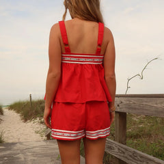 Woman wearing a red outfit with white trim on a beach path
