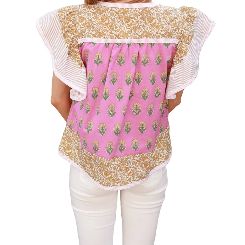 Back view of a person wearing a floral and pink patterned top with white pants