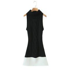 Black sleeveless dress with white hem on a hanger against a white background