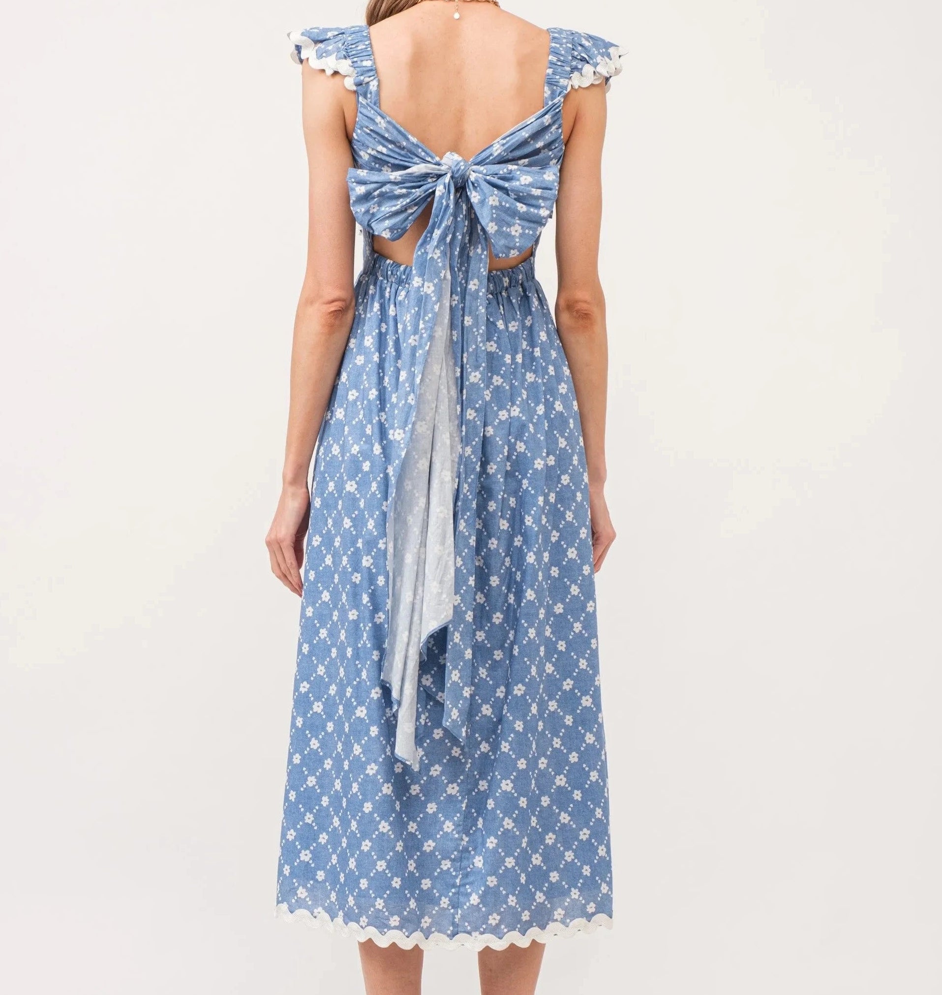 Blue patterned dress with a bow detail on a white background