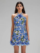 Woman wearing a blue floral dress on a gray background