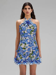 Woman wearing a blue floral dress on a gray background