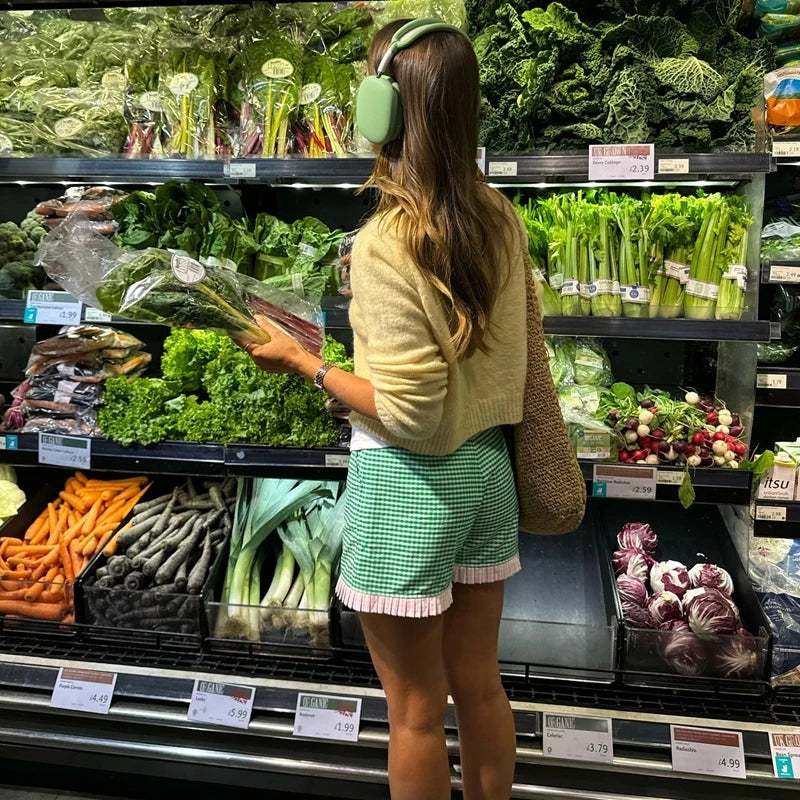 Women's charming green plaid shorts with ruffled hem.