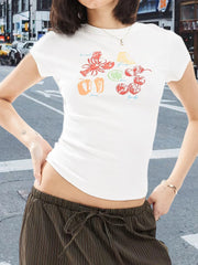 Person wearing a white t-shirt with colorful graphics on a city street.