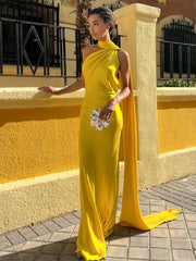 Woman in a yellow evening gown standing against a yellow wall.