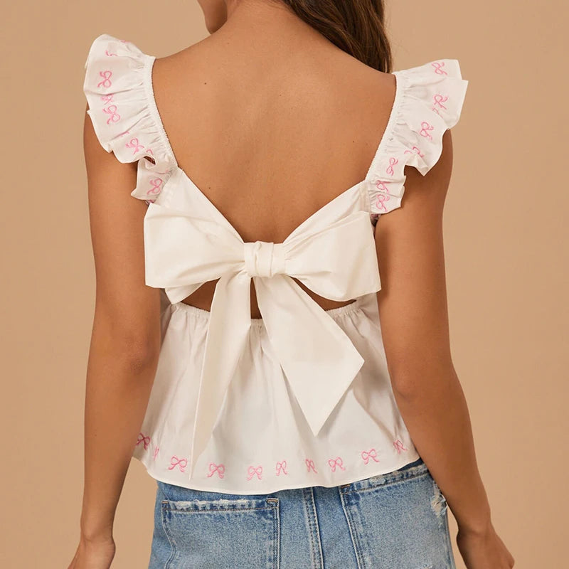 White blouse with ruffled sleeves and a bow detail