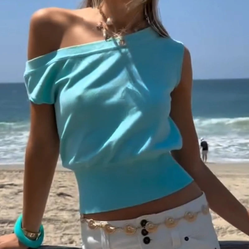Woman wearing a light blue off-shoulder top on a beach