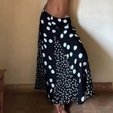 Black skirt with white polka dot pattern on a plain background