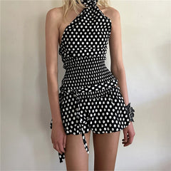 Black and white polka dot dress worn by a person against a plain background