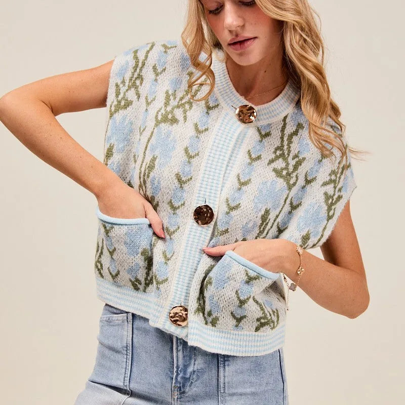 Woman wearing a patterned vest with floral design on a plain background