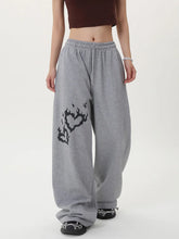 Person wearing gray sweatpants with a black design