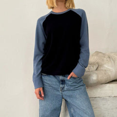 Person wearing a blue and black long-sleeve shirt with jeans