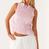 Woman wearing a pink sleeveless top with ruched details close-up