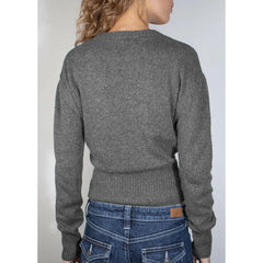 Person wearing a gray sweater and blue jeans on a plain background