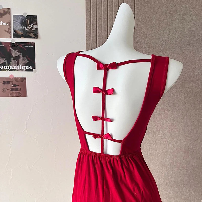 Red dress with open back on a mannequin against a neutral wall.