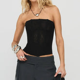 Woman wearing a black strapless top and black pants - front view