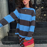 Person wearing a blue and gray striped sweater with a decorative door in the background