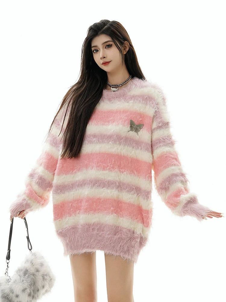 Woman wearing a pink and white striped sweater with a butterfly design