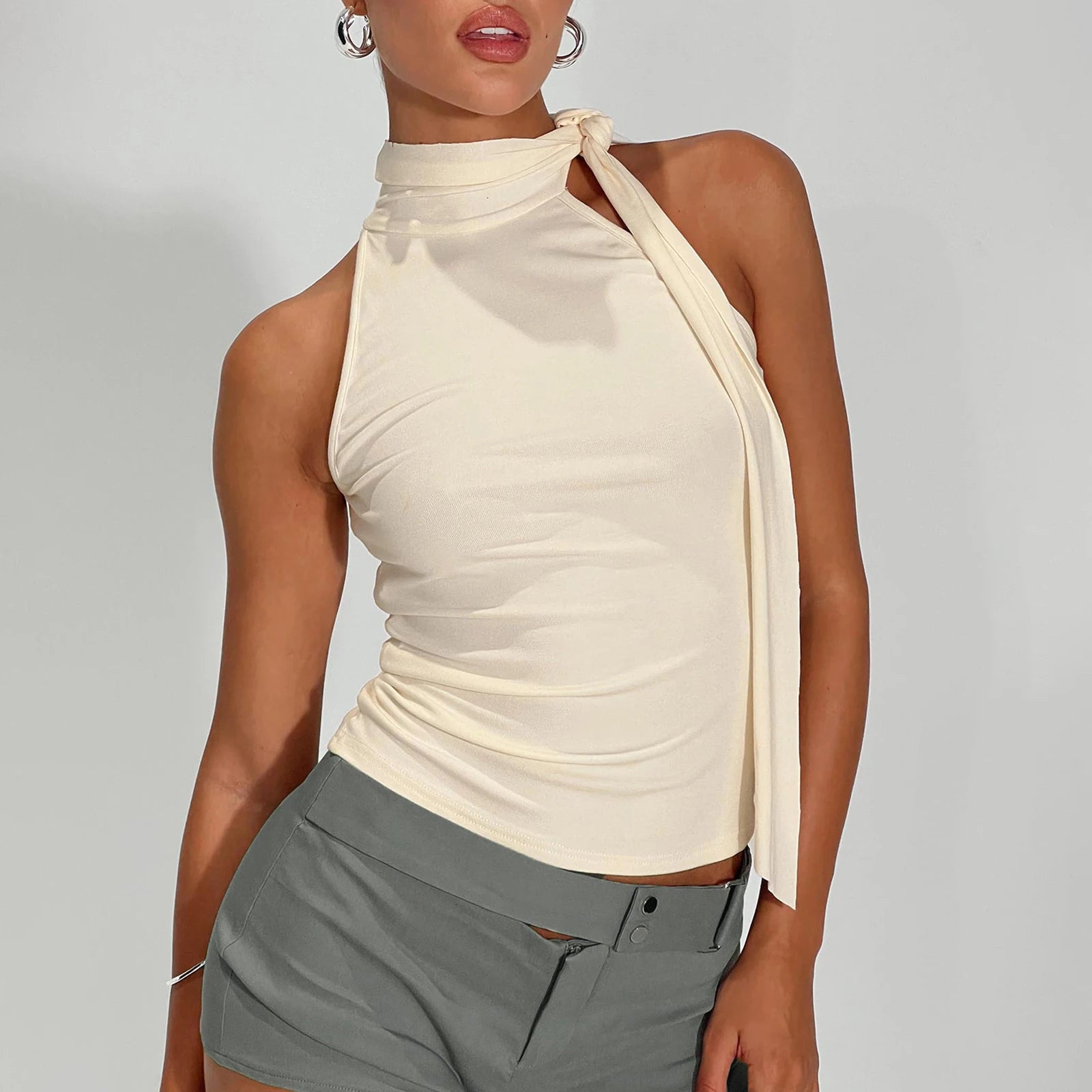 Model displaying a mock neck tie-up tank top in a solid color.