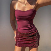 Maroon strapless dress with sequin skirt on a plain background