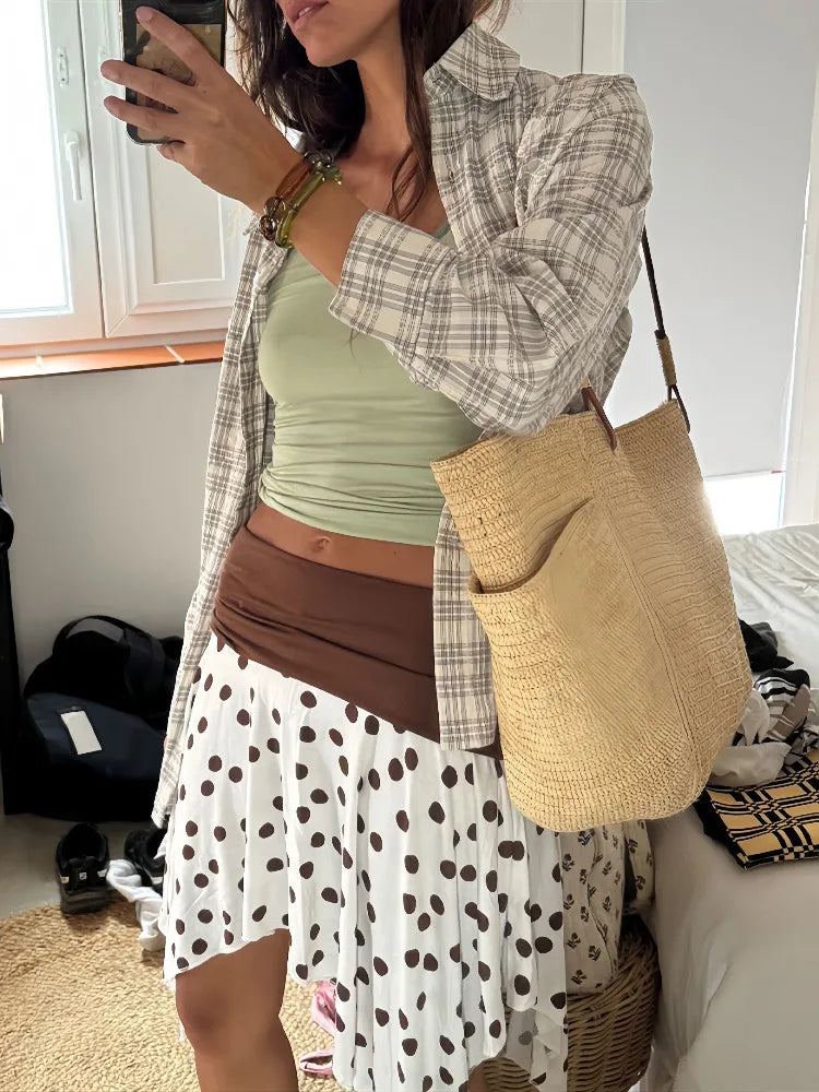 Women's polka dot low rise irregular short skirt with A-line silhouette.