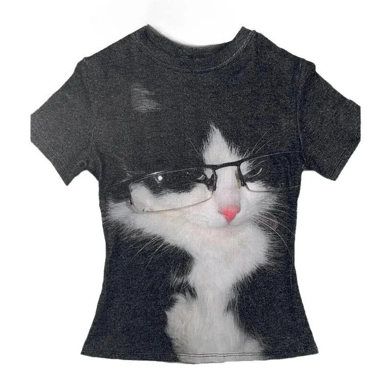 A short-sleeve crewneck t-shirt in dark charcoal gray, featuring a large graphic print of a black and white cat wearing black-rimmed glasses.