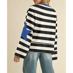 Person wearing a black and white striped sweater with blue accents on a beige background