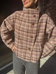 Person wearing a plaid jacket with a blurred background