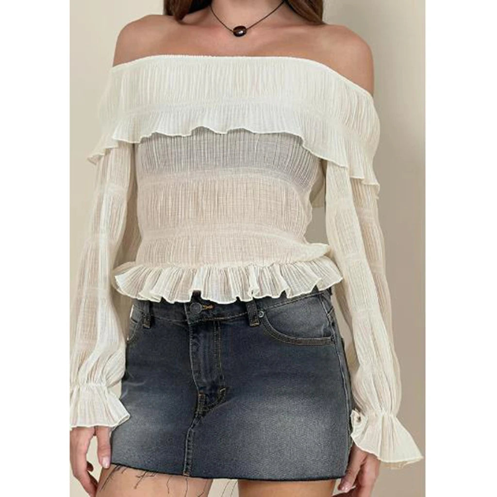 White off-shoulder blouse with ruffled details worn over a denim skirt.