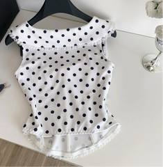 White polka dot top on a hanger