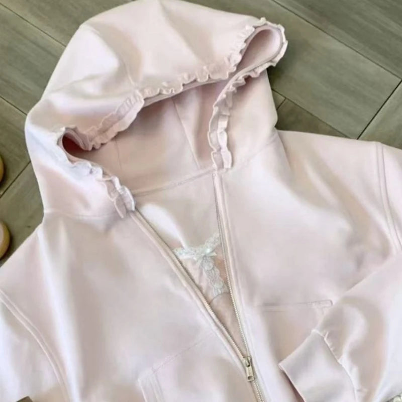 Light pink hoodie with ruffle details on a wooden floor