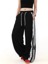 Black track pants with white stripes