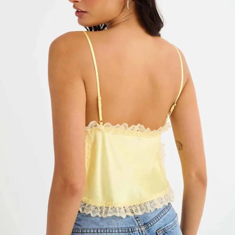 Model displaying a short lace trim satin cami top with an open back.