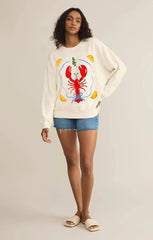 Woman wearing a white sweatshirt with a red lobster design
