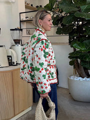 Person wearing a colorful quilted jacket in a kitchen setting
