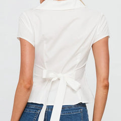 White top with a tie detail worn by a person- belted