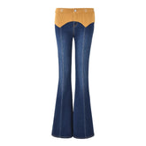 Blue flared jeans with mustard yellow top section on a white background
