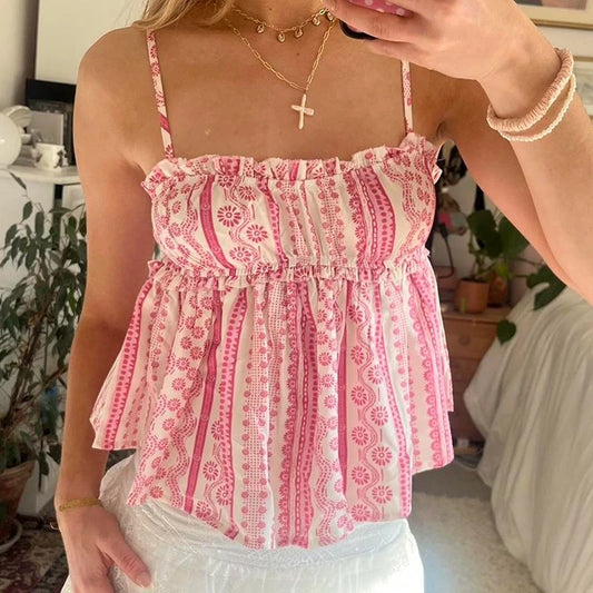Person wearing a pink and white patterned top in a casual indoor setting