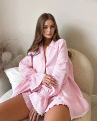 Woman wearing a pink robe sitting on a couch.
