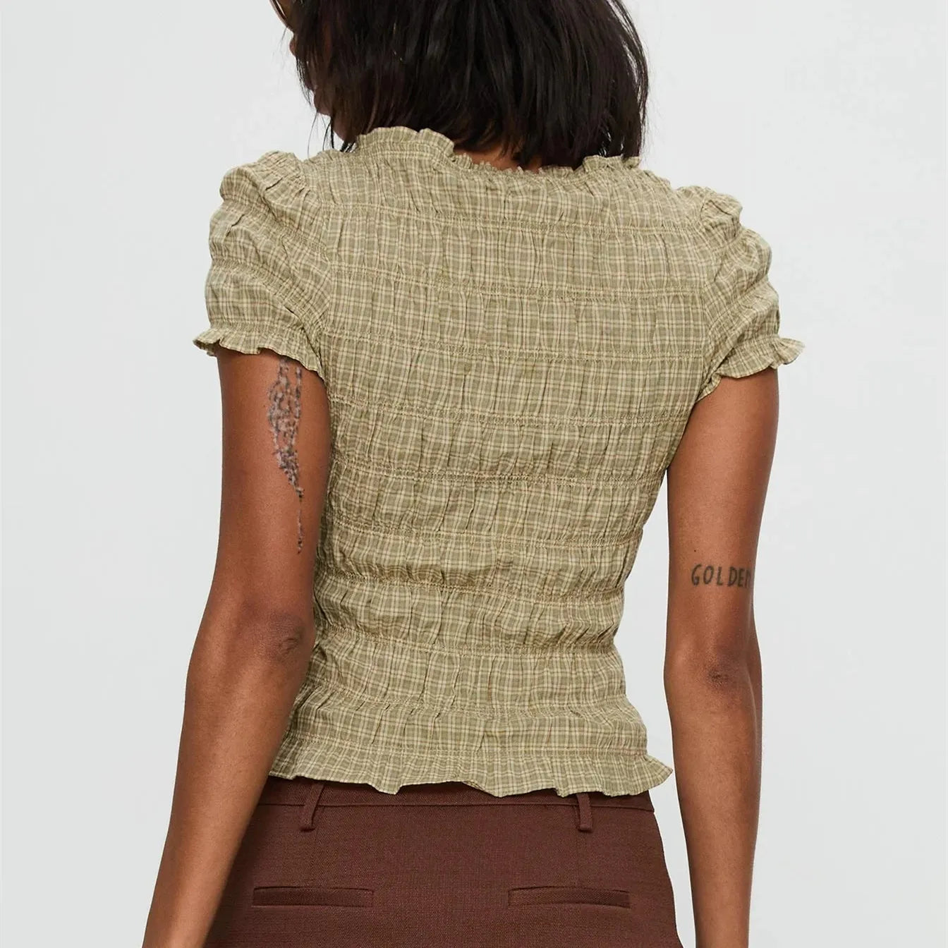 Women's smocked short sleeve top with V-neck and bow detail.