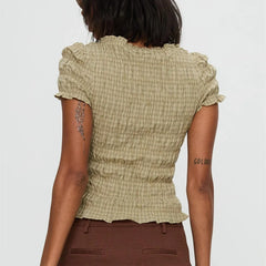 Women's smocked short sleeve top with V-neck and bow detail.