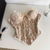 Delicate lace top with floral embroidery on a white surface