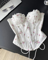 White lace corset with floral patterns on a black surface