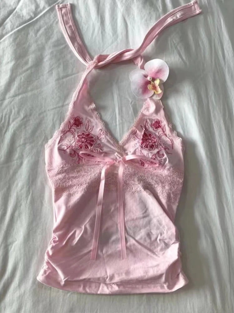 Pink lace babydoll dress with floral embroidery on a light gray background